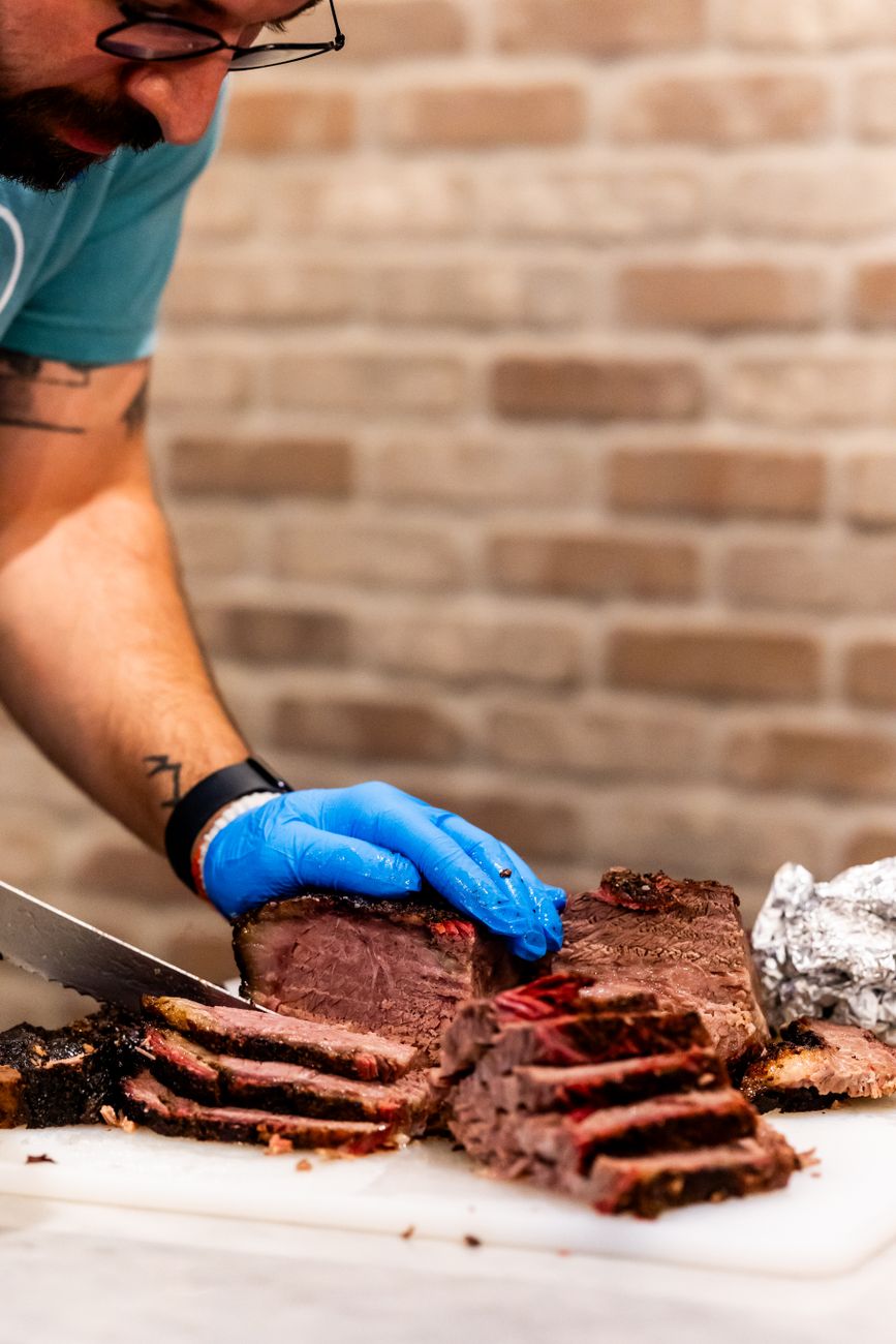 A chef slicing smoked brisket